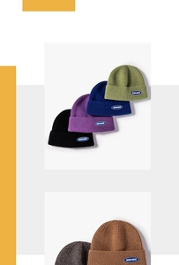 Detail of ribbed knit winter beanies with embroidered logo patch in various colors