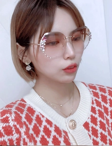 Detail of rimless gradient sunglasses with floral rhinestone accents on women