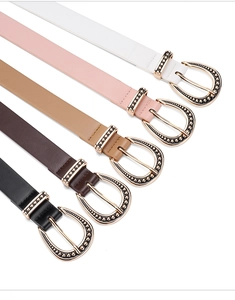 Detail showing five assorted leather belts with vintage embossed metal buckles and studs