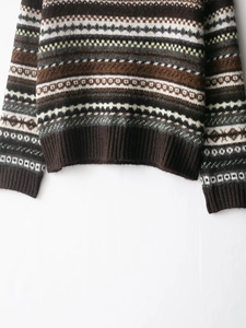 Detailed close-up of Fair Isle jacquard knit pattern and ribbed hem on brown sweater