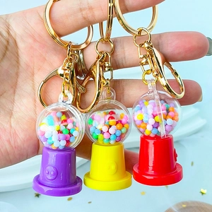 Creative mini gashapon machine keychains with colorful bases and golden metal clasps
