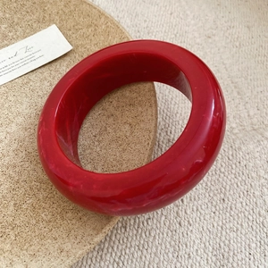 Red marble resin bangle with a wide circular design for a minimalist retro jewelry look