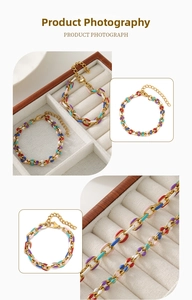 Macro detail of gold-plated chain featuring colorful enamel links and lobster clasp