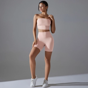 Close-up of pink ruched tube top and high waist yoga shorts set on model in studio