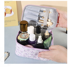 Detail of floral makeup bag interior featuring dedicated brush slots and large main compartment
