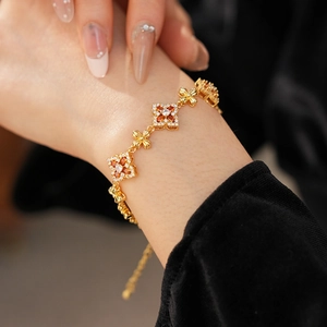 Primer plano detallado de la pulsera vintage dorada con circonitas naranjas y blancas