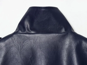 Detailed close-up of dark blue leather vest collar with precise stitching and grainy texture