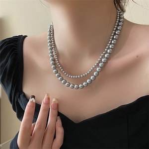 Detailed view of layered gray pearl necklace showing inner small and outer large beads