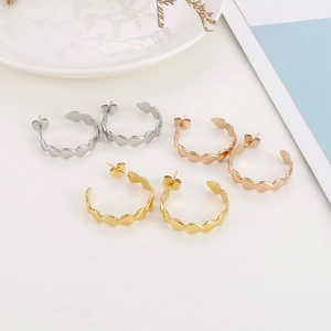 Three pairs of heart-shaped hoop earrings in silver, rose gold and gold finishes
