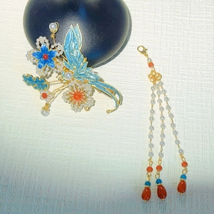 Détail d'une épingle à cheveux papillon en émail avec des glands de perles élégants
