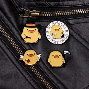 Detail von vier gelben Enten-Emaille-Pins auf einer schwarzen Lederjacke im Punk-Stil