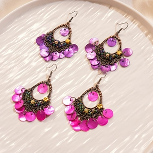 Detailed macro view of bohemian drop earrings with colorful beads and shell sequins