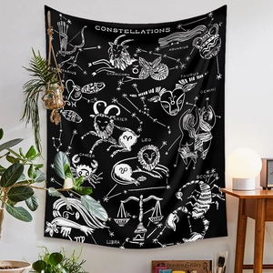 Detailed view of black bohemian tapestry featuring white constellations on a bedroom wall