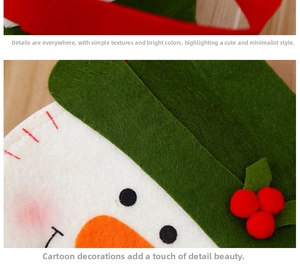 Detailopname van vilt kerstcadeauzakje met sneeuwpopmotief, oranje neus en groene muts