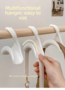 U-vormige witte plastic tassenhanger voor kledingroedes ter bescherming van de riemen