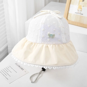 Detailed close-up of lace crochet pattern and cute green bow on baby sun bucket hat