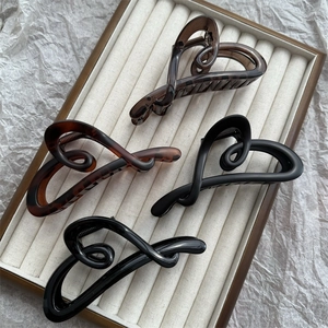 Elegant heart-shaped hair claw clips in matte and glossy black or brown finishes
