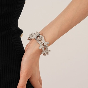 Vue détaillée d'un bracelet fleuri argenté plissé avec texture organique de métal liquide