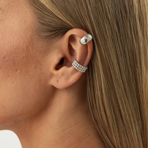 Detailed view of silver metal ear cuffs in smooth and beaded styles worn on ear