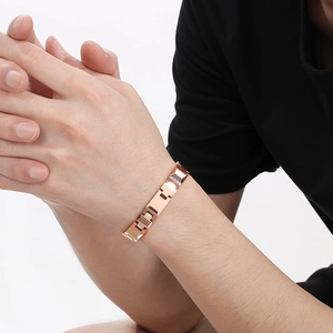 Gros plan d'un bracelet minimaliste en acier au tungstène or rose sur un poignet d'homme