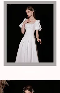 Close-up of white satin wedding dress with elegant pearls and bow puff sleeve detail