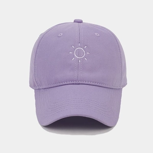 Close-up of a purple cotton baseball cap featuring detailed white sun pattern embroidery
