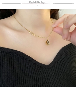 Close-up of gold plated sunburst necklace with tiger eye gemstone on a model