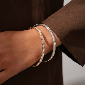 Close-up of elegant gold and silver bracelets with sparkling crystals on a wrist