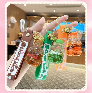 Detail of creative soda bottle keychains with colorful liquid and Good Luck silicone straps