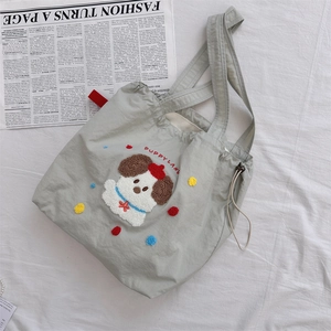 Detail of canvas tote bag featuring puppy embroidery and colorful plush dots decor