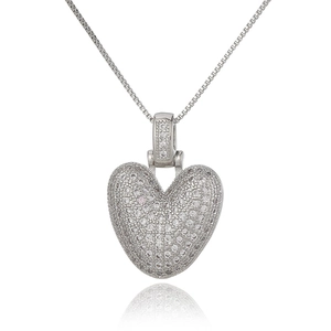 Macro shot of silver heart pendant with pavé set crystals on a polished box chain