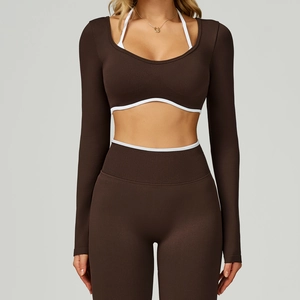 Detail of chocolate brown seamless yoga top featuring white halter straps and contrast trim