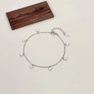 Bracciale minimalista in argento sterling S925 con eleganti perle su sfondo beige tenue