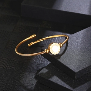 Golden Roman numeral open cuff bracelet with twisted cable band on black display