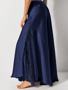 Detail of elegant navy satin midi skirt featuring delicate lace patchwork and side slit