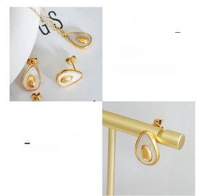 Detail of avocado jewelry set in titanium steel with 18K gold plating and shell inlay