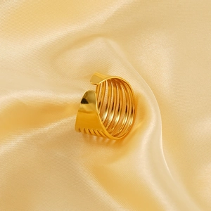 Dettaglio dell'anello geometrico in oro 18k traforato con texture a strati su seta