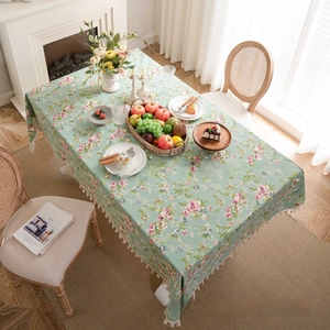 Detailed close-up of floral cotton linen tablecloth with elegant white fringe edges
