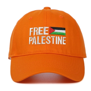 Dettaglio del ricamo Free Palestine e della bandiera su berretto di cotone arancione