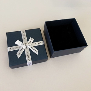 Top-down view of dark blue square jewelry gift box with a Crystal Jewelry ribbon bow