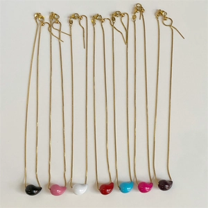 Detail of colorful bean-shaped pendants on gold stainless steel chains necklace set