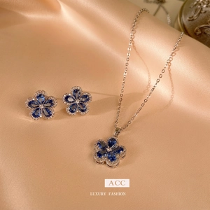 Elegant S925 silver flower necklace and earrings set with blue teardrop stones on silk