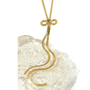 Elegant gold bow necklace with shimmering diamonds on a sleek flat snake chain