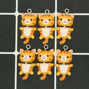 Detailed view of six orange tabby cat resin charms arranged on a black mesh background