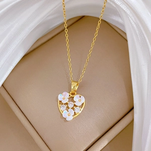 Elegant gold heart pendant necklace with white floral zircons on a soft beige background