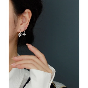 Close-up of S925 silver star earrings with crystal inlay on model's ear