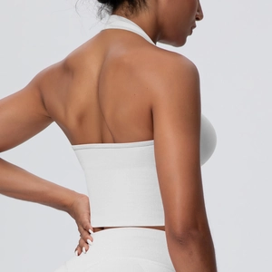 Detail view of white seamless knitted sports bra featuring racerback and ribbed waist texture