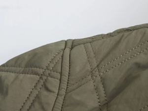 Gros plan sur la veste mode urbaine vert olive avec motif de matelassage en losange