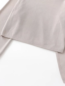 Close-up of light grey knit sweater showing rolled cuffs and fine ribbed texture