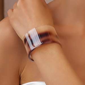 Detail of wide acetate cuff bracelet with marble texture and polished brown tortoiseshell